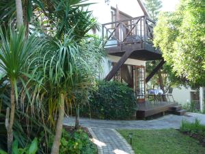 a house with a balcony with a staircase in the yard at Inn2Wilderness Guesthouse in Wilderness