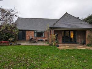 a brick house with a patio in the yard at Cosy Garden View Room in East Grinstead