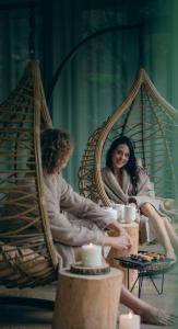 a woman sitting in a swing with a girl at Astoria Resort in Riva del Garda