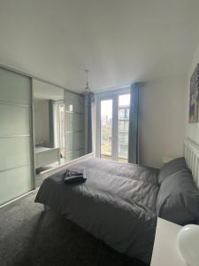 ein Schlafzimmer mit einem Bett und einem großen Fenster in der Unterkunft En-suite Private Room in Manchester