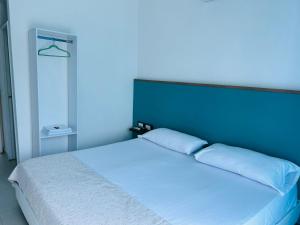 1 dormitorio con cama blanca y cabecero azul en Finca en Ricaurte La Puerta del Ángel, en Ricaurte