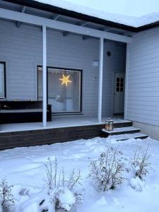 a star in the window of a house in the snow at Luxurious Apartment in Rovaniemi