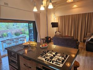 a kitchen with a stove top oven next to a living room at Oorlogs Kloof Mountain Retreat Montagu in Montagu