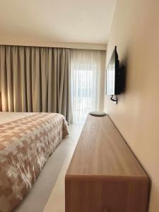 1 dormitorio con 1 cama y TV en la pared en Casabell 3 Caminito del Rey en Valle de Abdalagís