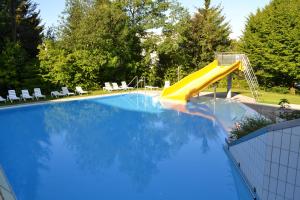 a swimming pool with a yellow slide in a yard at Ferienvermietung Sporer in Sankt Englmar