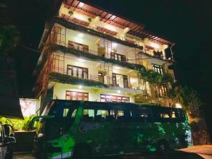 a bus parked in front of a building at night at Nature Walk Resort in Kandy