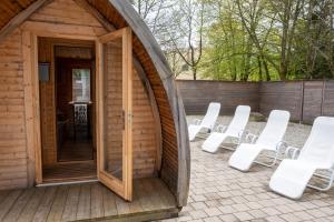 - un groupe de chaises blanches dans un bâtiment en bois dans l'établissement Ferienvermietung Sporer, à Sankt Englmar