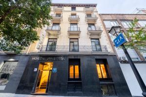 - un bâtiment dans une rue avec un panneau devant dans l'établissement Hostal Ballesta, à Madrid