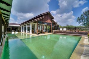 a swimming pool in front of a house at Villapadu Bayu in Kuala Terengganu
