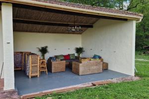 une terrasse avec un canapé et des chaises dans une maison dans l'établissement La Tour de Pérès, à Ayguetinte