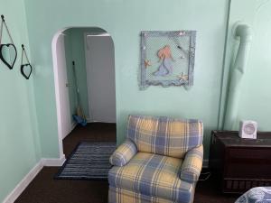 ein Wohnzimmer mit einem Stuhl und einem Bild an der Wand in der Unterkunft Beach Side Studio #1 apts in North Camellia Acres