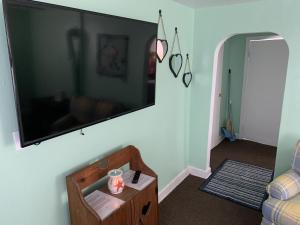 ein Wohnzimmer mit einem großen Flachbild-TV an der Wand in der Unterkunft Beach Side Studio #1 apts in North Camellia Acres