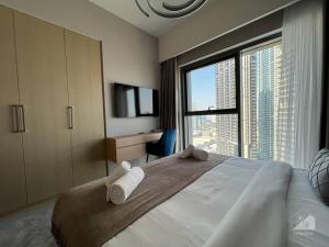 una camera da letto con un letto grande con una grande finestra di Luxury 3Bedroom Apt with balcony in Downtown a Dubai