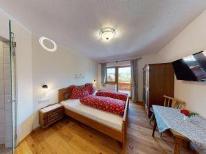 a bedroom with a bed with red pillows at Bauernhof Bichlhof in Söll