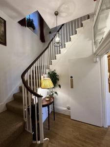 un pasillo con una escalera con una mesa y una lámpara en Watermead House, en Chard