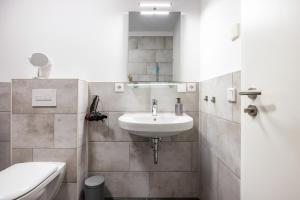 a bathroom with a sink and a toilet at Ferienwohnung Lampa in Wasbüttel +11 photos