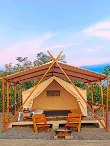 a tent with two chairs and a table at Wawowow in Tomohon