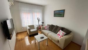 uma sala de estar com um sofá e uma cadeira em Apartment Krstanovic em Banja Luka