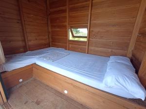 - un lit à l'intérieur d'une cabane en bois dans l'établissement Wawowow, à Tomohon