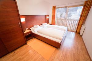 ein Schlafzimmer mit einem Bett und einem großen Fenster in der Unterkunft WOHNEN by LIZZY in Wagrain