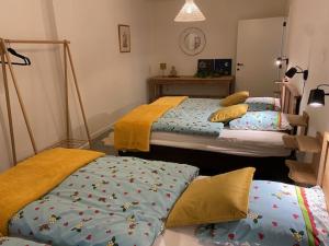 1 dormitorio con 2 camas con sábanas en Vakantiewoning Het Wielje Maasland en Kinrooi