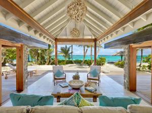 an outdoor living room with a table and chairs at Petit St. Vincent Resort in Petite Martinique