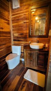 a wooden bathroom with a toilet and a sink at Yaku Hostel in Playa Mendiguaca