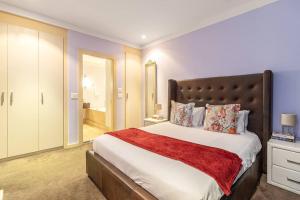um quarto com uma cama grande e um cobertor vermelho em 2 Bedroom Oasis in MRP em Cidade do Cabo