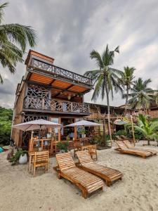 un complejo con sillas y sombrillas en la playa en Yaku Hostel en Playa Mendiguaca