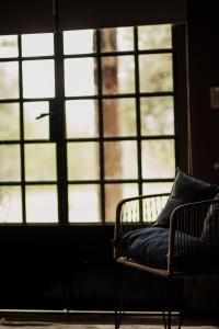una silla con una almohada sentada frente a una ventana en El Pinar de La Caballeriza en San Rafael