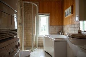 a bathroom with a shower and a sink and a tub at Bergmannsgata 3 in Røros