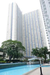 un gran edificio con una piscina frente a él en 1 BR SMDC North Edsa Condo with Balcony & Netflix, en Manila