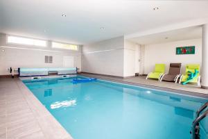 a large swimming pool in a hotel room at Villa Yana Bretagne Piscine Intérieure partagée et Spa Privatif 100m de la Plage in Sibiril
