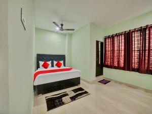 Un dormitorio con una cama con almohadas rojas. en SPOT ON Sri Datta Grand Inn, en Warangal