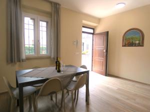 comedor con mesa, sillas y puerta en SCAPPO IN UMBRIA, Apartments en Narni Scalo