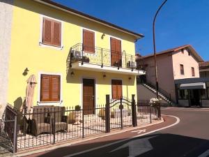 una casa amarilla con una valla al lado de una calle en SCAPPO IN UMBRIA, Apartments en Narni Scalo