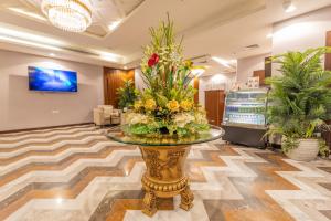 a lobby with a glass table with flowers on it at Laten Suites Al Salim Plaza in Jeddah