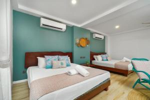 um quarto com 2 camas e uma parede azul em Villapadu Bayu em Kuala Terengganu