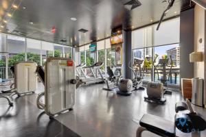 un gimnasio con equipo cardiovascular en un edificio con ventanas en Upper studio with Balcony,Pool and Gym, Near Beach, en Hallandale Beach