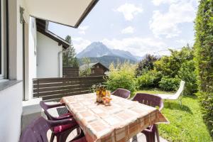 einen Tisch und Stühle auf einer Terrasse mit Bergen im Hintergrund in der Unterkunft Feriensiedlung Trü 22 in Scuol