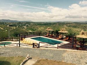 a swimming pool with a view of the mountains at Cabañas Terrazas del Sol in Villa Carlos Paz