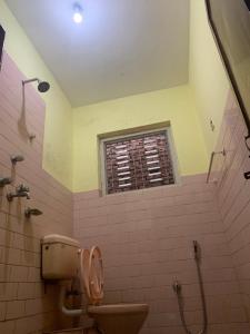 een badkamer met een toilet en een raam bij Osho Gaurishankar Meditation Center in Kathmandu