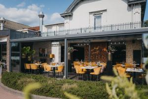 ein Restaurant mit Tischen und Stühlen auf einer Terrasse in der Unterkunft Hotel Schimmel in Woudenberg