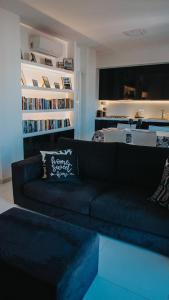 a living room with a black couch and a book shelf at Principato di Baragallo - Free Private Parking in Sanremo