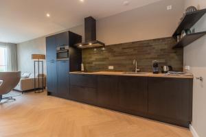 a kitchen with a sink and a counter top at Residentie de Schelde - Apartments with hotel service and wellness in Cadzand-Bad