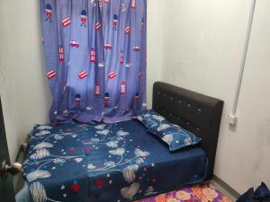 a bed in a room with a blue curtain at My Soul Homestay in Kampong Ru Sepuloh