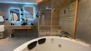 Suites Aix la Chapelle, Exclusive Apartments, Wellness and more, Aachen City في آخن: حمام كبير مع حوض ومغسلة