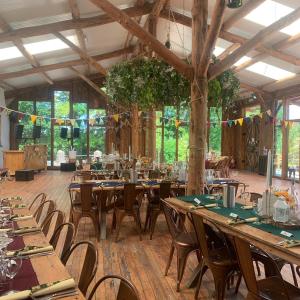 uma sala de jantar com mesas e cadeiras de madeira em Ceridwen Holiday Home em Llandysul
