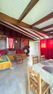 ein Wohnzimmer mit einem Bett und einem Tisch in der Unterkunft Jolie maison de vacances à Pointe-Noire in Pointe-Noire