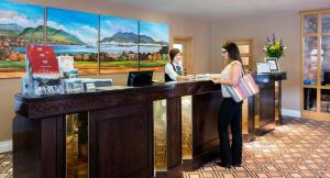 a woman standing at a counter in a hotel lobby at Castlerosse Park Resort in Killarney